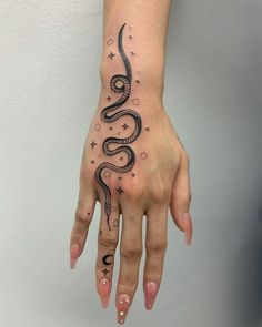 a woman's hand with a snake tattoo on it