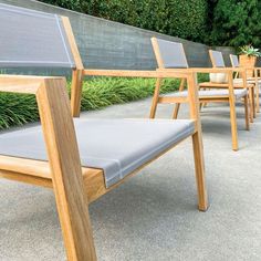 a row of wooden chairs sitting next to each other on top of a cement floor