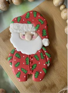 a santa clause cookie sitting on top of a wooden cutting board