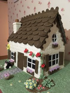 a cake shaped like a house with flowers on it