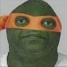 a man wearing a ninja mask and holding his head with one hand while looking at the camera