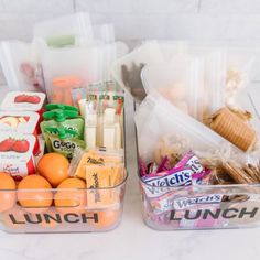 two plastic containers filled with food sitting on top of a white marble countertop next to each other