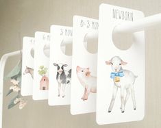 four door hangers with pictures of farm animals on them hanging from a metal hook