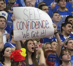 a group of people with painted faces and signs in the stands at a sporting event