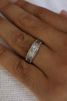 a close up of a person's hand with a wedding ring on their finger