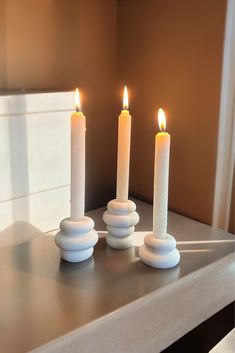 three lit candles sitting on top of a counter