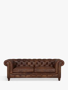 a brown leather couch sitting on top of a white floor