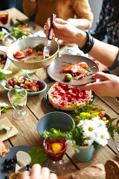 people sitting at a table eating pizza and salad