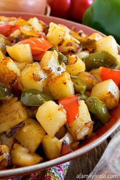 a bowl filled with potatoes and peppers on top of a table