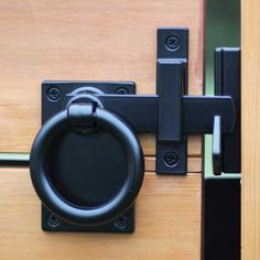 a close up of a door handle on a wooden door with black handles and an oval knob