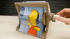 a person is opening up a box with a cartoon character on the front and side