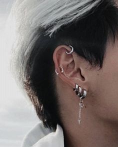 a man with white hair and piercings on his ear