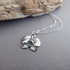 sterling silver orchid flower necklace, 5/8" - A sterling silver charm, measuring 5/8" (15 mm) in length and across.   - Necklace is 1.5 mm cable chain, with lobster clasp and locking jump rings, all solid sterling silver.  - Charm has blackening (oxidizing) to bring out the details. - Flower is realistic looking, back has textured detail. - Packaged in a modern circular tin, ready for gift giving, and comes with a silver polish pad and care instructions. Customize chain length or "charm only" o Silver Polish, Top Rings, Botanical Jewelry, Floral Pendant, Orchid Flower, Flower Jewellery, Flower Necklace, Sterling Silver Charm, Jump Rings