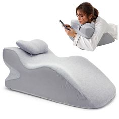 the woman is using her cell phone while sitting on an inflatable bed pillow