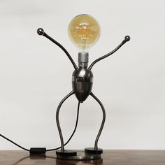 a lamp that is sitting on top of a wooden table next to a light bulb