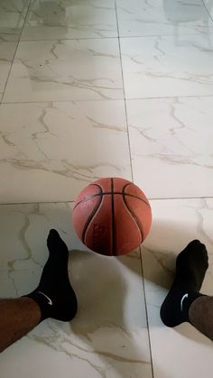 two feet are on the floor with a basketball