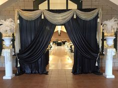 an entrance way with black drapes and white pillars