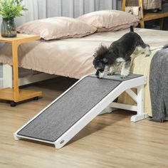 a small dog standing on top of a pet ramp that is attached to a bed