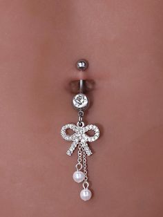 a belly piercing with a bow and pearls on it's side, attached to a navel ring