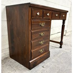 a wooden desk with three drawers on it