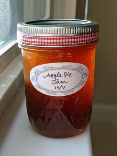 a jar of apple pie jam sitting on top of a window sill