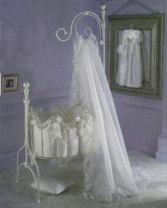 a baby crib with a white dress on it