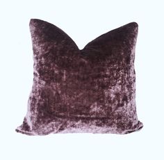 a purple velvet pillow on a white background