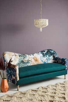 a living room with purple walls and a blue couch next to a rug on the floor