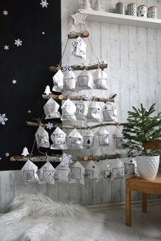 a christmas tree made out of coffee cups is hanging on the wall next to a table