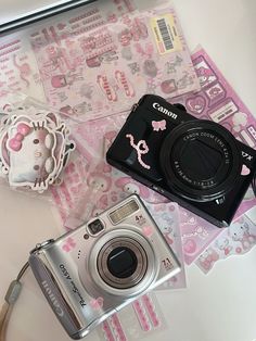 a camera and some stickers sitting on top of a table next to each other