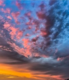 the sky is filled with colorful clouds as the sun sets