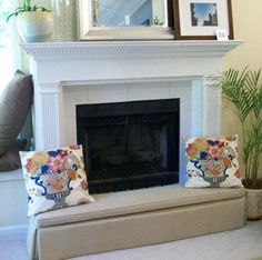 a living room with a fire place and pictures on the mantle