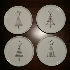 four white plates with christmas trees on them