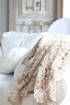 a crocheted blanket sitting on top of a white couch