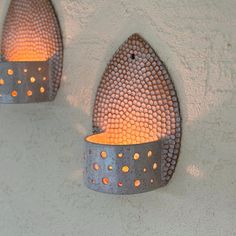 two metal wall sconces with orange lights on the outside and inside of them