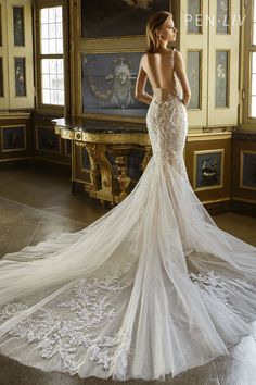 a woman in a wedding dress looking off into the distance with her back to the camera