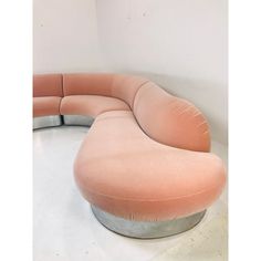 a pink couch sitting on top of a white floor