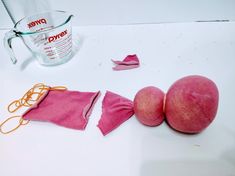 two pieces of pink fabric next to a measuring cup