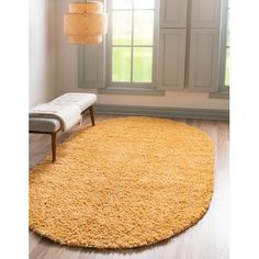 a large yellow rug in the corner of a room next to a chair and window