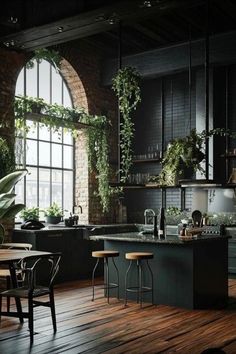 an industrial kitchen with wooden floors and green plants hanging from the ceiling, along with black walls