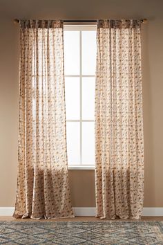 a window with curtains and a rug in front of it