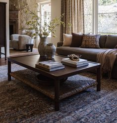 a living room filled with furniture and a large vase on top of a coffee table