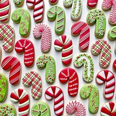 many decorated cookies are displayed on a white surface with green, red and pink decorations