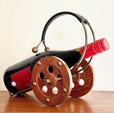 a wine bottle holder made out of wooden reels and metal spools on a table