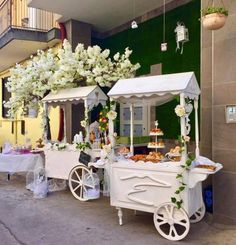 a white cart filled with food next to a building