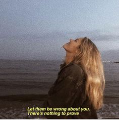 a woman looking up at a kite flying in the sky with a quote written on it