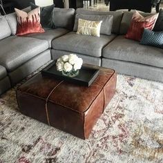 a living room filled with lots of furniture and pillows on top of a carpeted floor