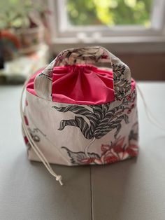 a bag sitting on top of a counter next to a window with a red bow