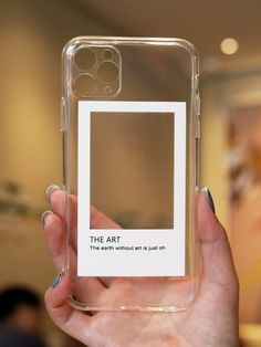 a person holding up a clear phone case with the words the art in black on it