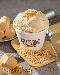 a scoop of ice cream on a plate with crackers and spoons next to it